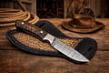 Cowboy Hunting Sheath Knife – 4" Damascus Steel Pinecone Handle - SHAM KNIVESCowboy KnifeSHAM KNIVESCowboy hunting sheath knife with 4 inch Damascus steel blade and pinecone handle on rustic wooden table with cowboy rope and hat