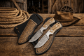 Cross Draw Sheath Knife – 3.75" Damascus Steel Pinecone Handle - SHAM KNIVESCowboy KnifeSHAM KNIVESCross draw sheath knife with 3.75 inch Damascus steel blade and pinecone handle on rustic wooden table with cowboy rope and hat