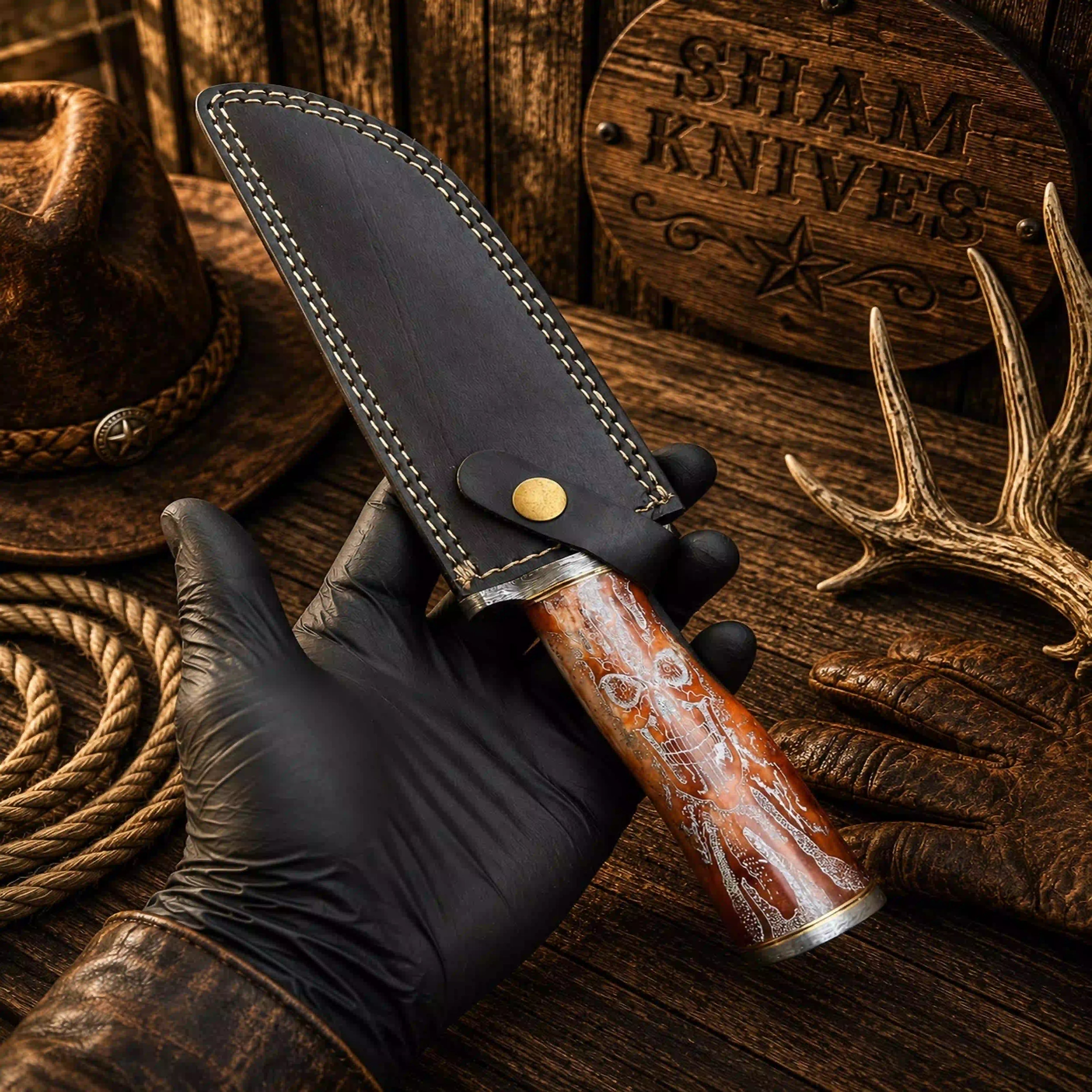Skull-handle Bowie with orange-red camel bone and patterned metal guard
