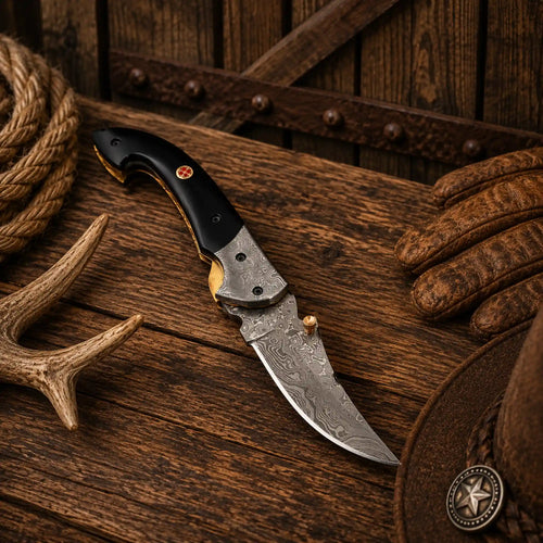 Premium Raindrop Damascus folding knife featuring a razor-sharp 1095 and 15N20 steel blade, buffalo horn handle, under lock mechanism, and leather sheath.