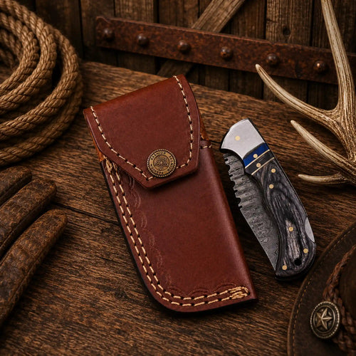 Handmade EDC folding knife with Damascus steel blade, polished steel bolster, black Pakka wood scales, and genuine leather carrying sheath.