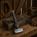 Viking hammer with Valknut engraving and Odin carved handle on rustic wooden table in barn setting with rope and gloves